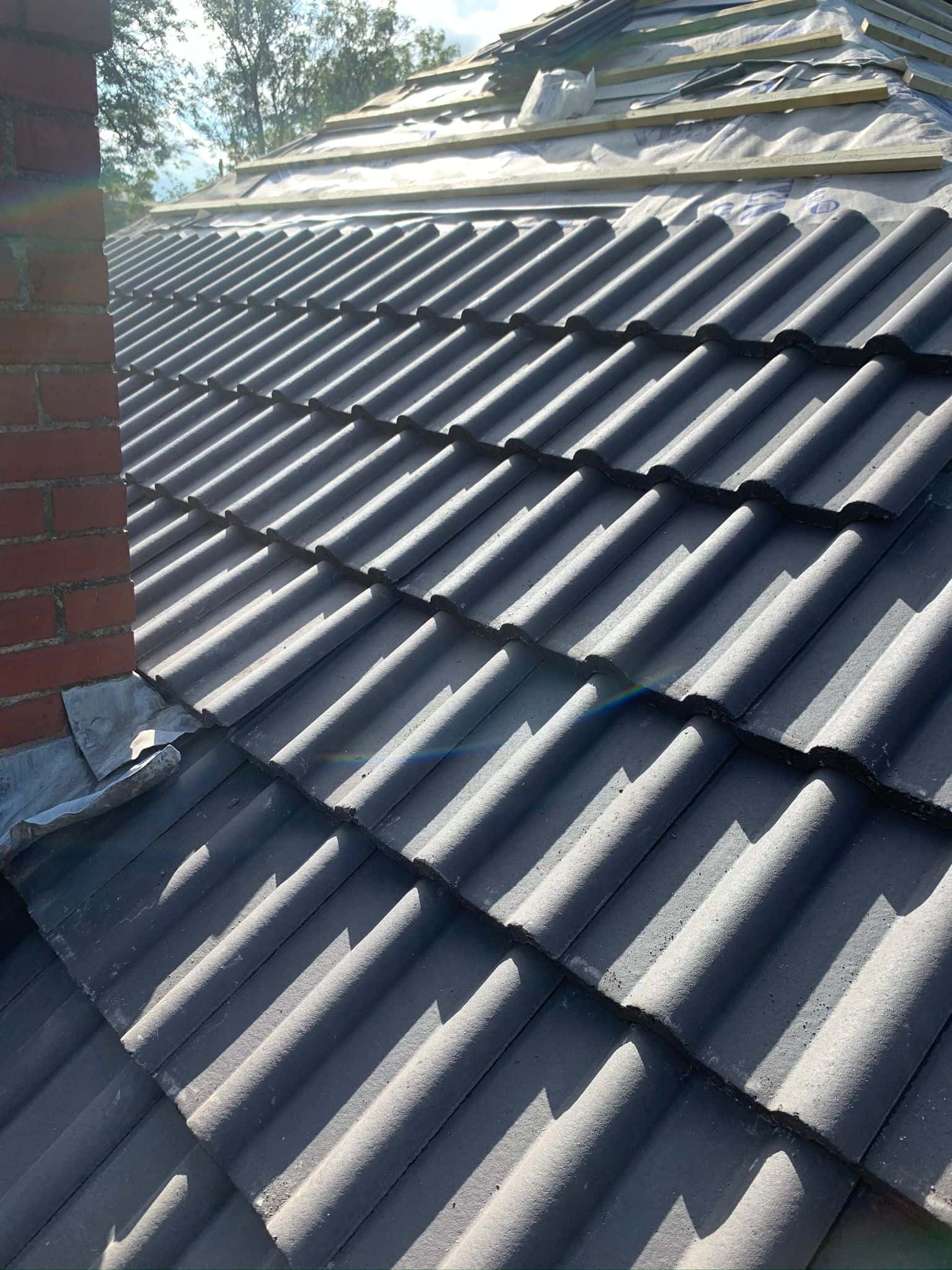 This is a photo of a re-roof where the works are in progress, the felt, batten and a few rows of tiles have been installed by EF Roofing Doncaster